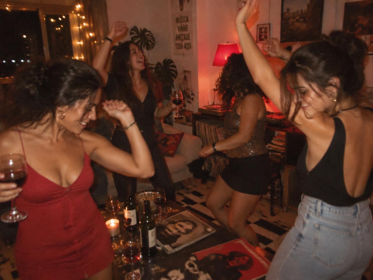 Mulheres dançando juntas em uma festa em casa